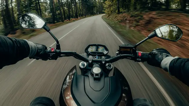 Motorista circulando por una carretera, vista desde la moto