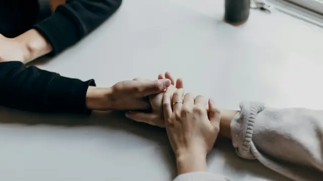 Manos que se sostienen como gesto de apoyo a la familia