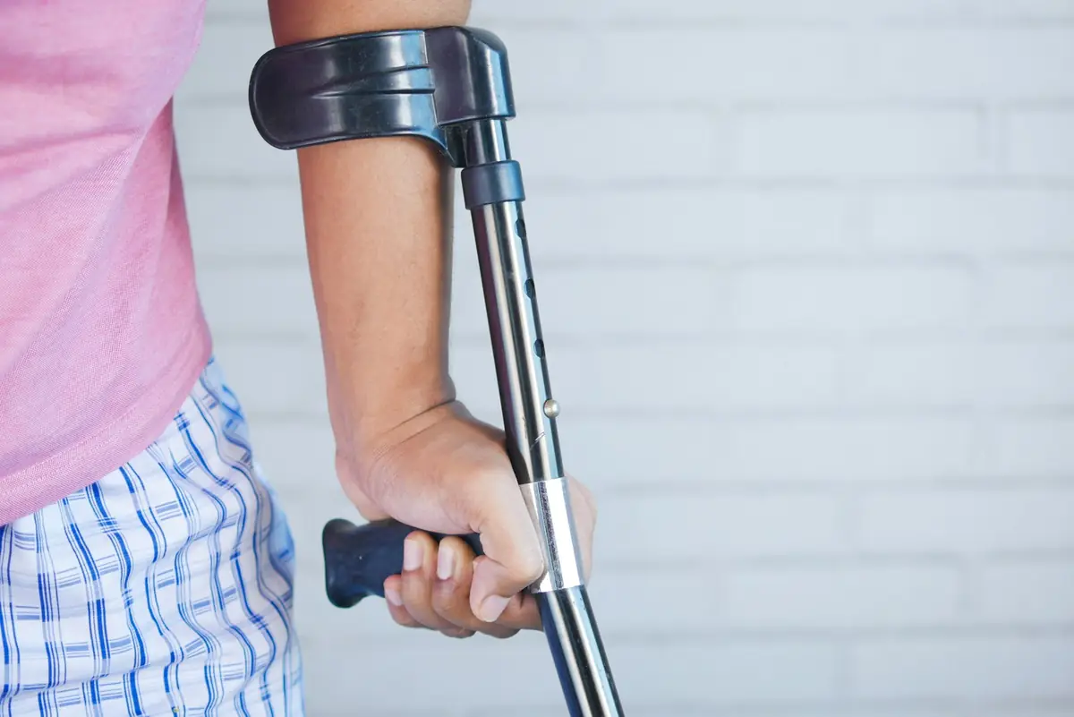 Persona apoyándose en una muleta durante su recuperación