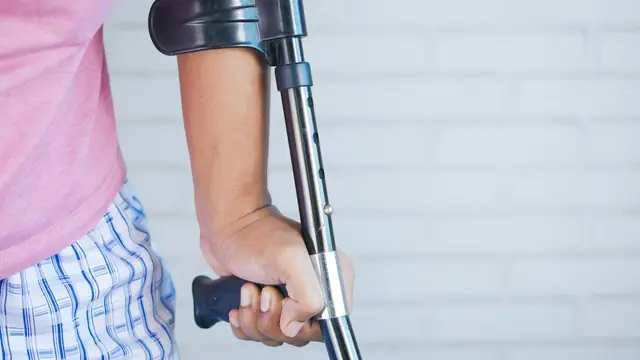 Persona apoyándose en una muleta durante su recuperación