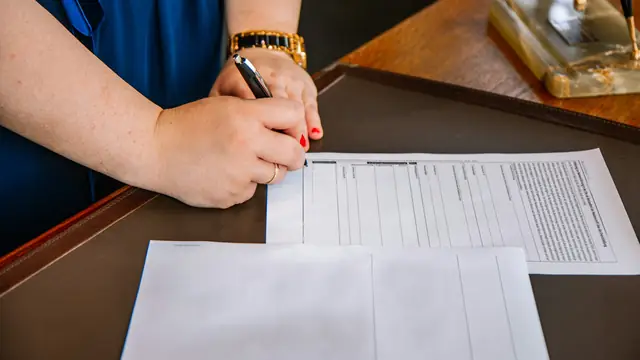 Persona revisando y anotando una oferta de indemnización